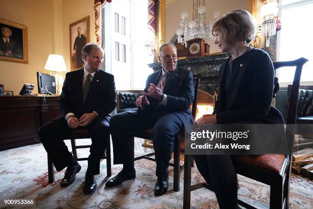 Senate Minority Leader Sen. Chuck Schumer speaks to Sen. Doug Jones and Sen. Tina Smith during a meeting at the U.S. Capitol January 3, 2018 in...