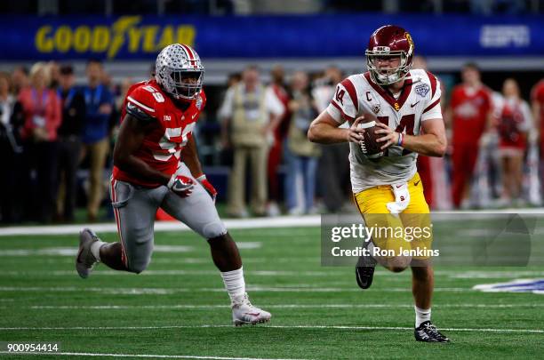 Sam Darnold of the USC Trojans runs from Tyquan Lewis of the Ohio State Buckeyes in the second half of the 82nd Goodyear Cotton Bowl Classic between...