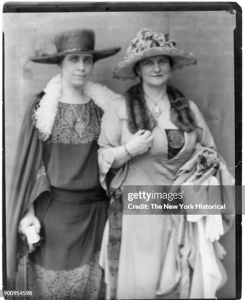 Black and white tone portrait of Frances Keyes and US First Lady Grace Coolidge, in fur-trimmed dresses and capes, large hats, 1924.