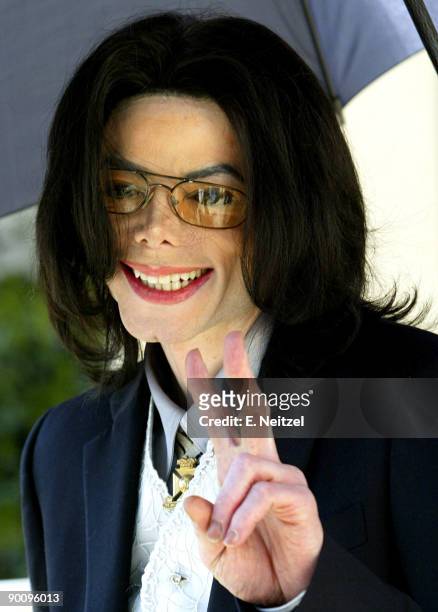 Michael Jackson flashes a peace sign at his supporters while he leaves the Santa Barbara County Superior Court in Santa Maria, California, on Friday...
