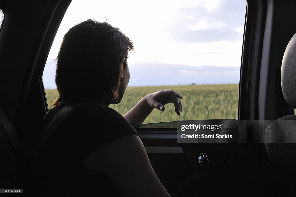 Woman at car window, in backseat
