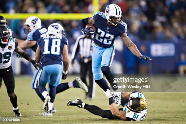 Derrick Henry of the Tennessee Titans runs the ball and breaks the tackle from Paul Posluszny of the Jacksonville Jaguars at Nissan Stadium on...