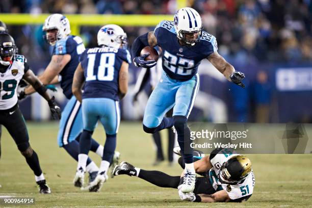 Derrick Henry of the Tennessee Titans runs the ball and breaks the tackle from Paul Posluszny of the Jacksonville Jaguars at Nissan Stadium on...