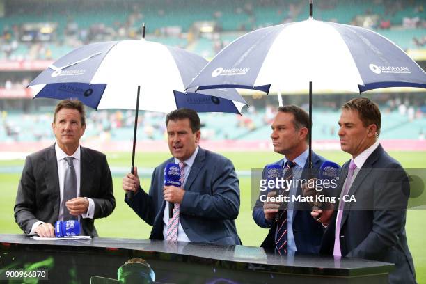 Channel nine commentators Mark Nicholas, Mark Taylor, Michael Slater and Shane Warne speak on camera as rain falls before the start of play during...