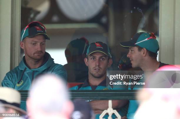 Jackson Bird, Mitch Marsh and Tim Paine of Australia look on as rain delays the start of play during day one of the Fifth Test match in the 2017/18...