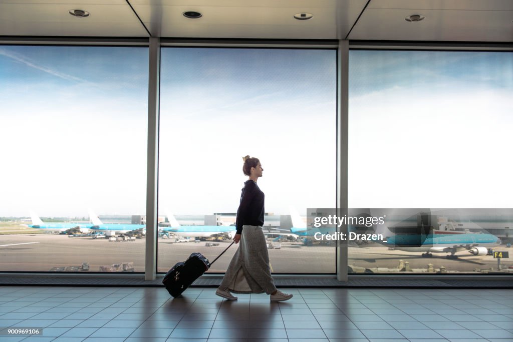 Mujer con maleta va a junta en el próximo vuelo