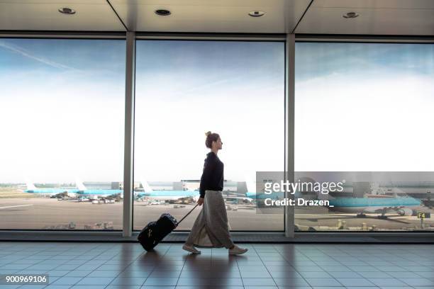 la donna con la valigia salirà a bordo del prossimo volo - aeroporto foto e immagini stock