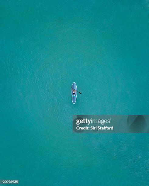 top down view of paddle boarder in water - lost item stock-fotos und bilder