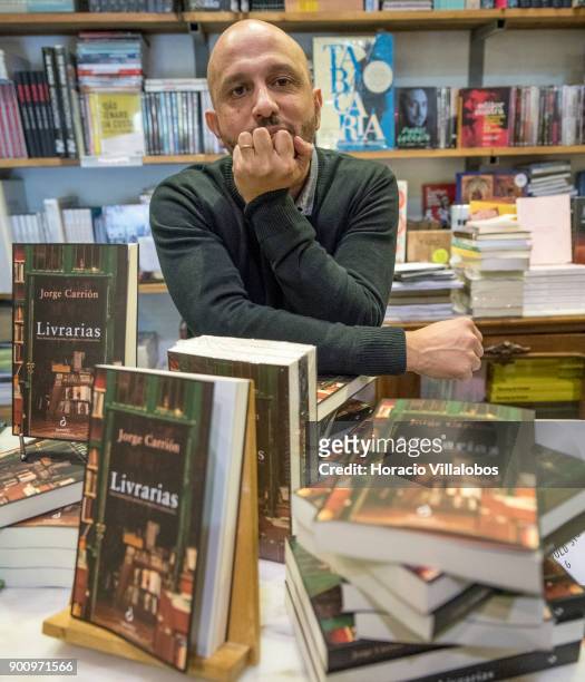 Spanish novelist and essayist Jorge Carrion seen behind copies of the Portuguese edition of his last book "Livrarias" at Ler Devagar bookstore in LX...
