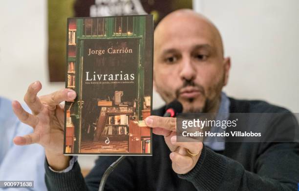 Spanish novelist and essayist Jorge Carrion holds a copy of the Portuguese edition of his last book "Livrarias" while talking about it at Ler Devagar...