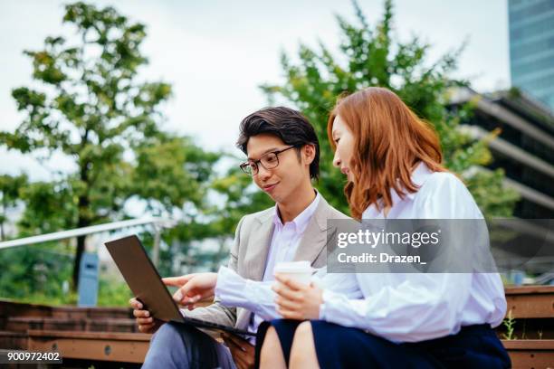 japanese business people using laptop on coffee break - work romance stock pictures, royalty-free photos & images