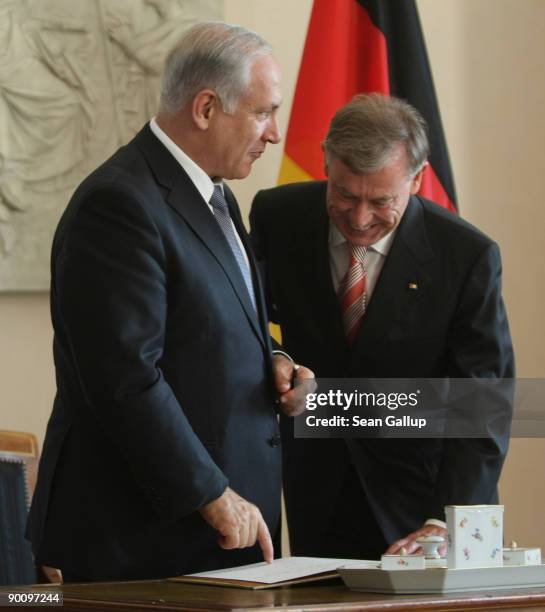 Israeli Prime Minister Benjamin Netanyahu shows his entry into an honourary guest book to German President Horst Koehler upon Netanyahu's arrival at...