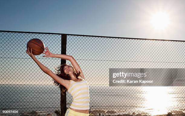 girl leaping to catch basketball - catching ball stock pictures, royalty-free photos & images