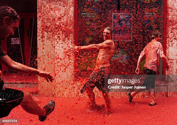 Revellers pelt each other with tomatoe pulp during the world's biggest tomato fight at La Tomatina festival on August 26, 2009 in Bunol, Spain. More...