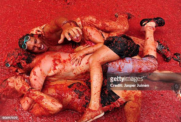 Revellers lay in tomato pulp during the world's biggest tomato fight at La Tomatina festival on August 26, 2009 in Bunol, Spain. More than 45000...