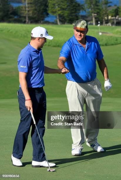 Justin Thomas and Chris Berman celebrate Justin's birdie putt on the ninth hole during practice for the Sentry Tournament of Champions at Plantation...