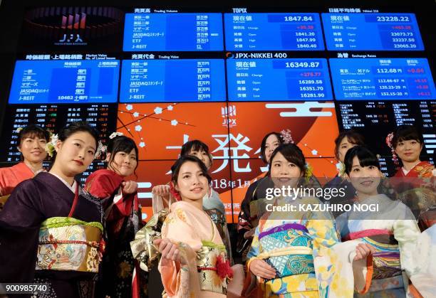 Women wearing traditional kimono outfits pose after the opening of the stock market for the year at the Tokyo Stock Exchange on January 4, 2018....