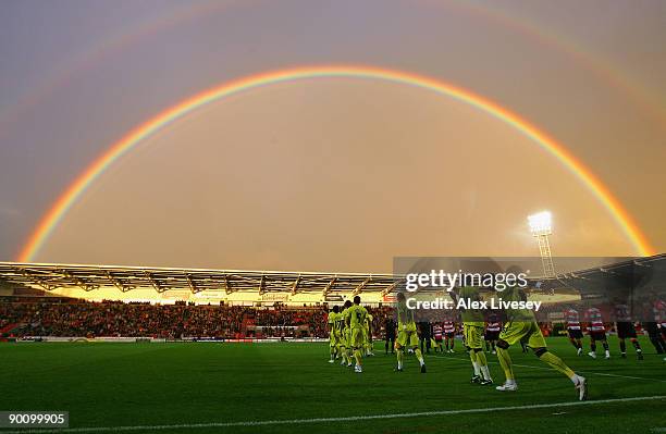 Tottenham Hotspur and Doncaster Rovers players run on to the pitch as a rainbow arcs over Keepmoat Stadium before the Carling Cup second round match...