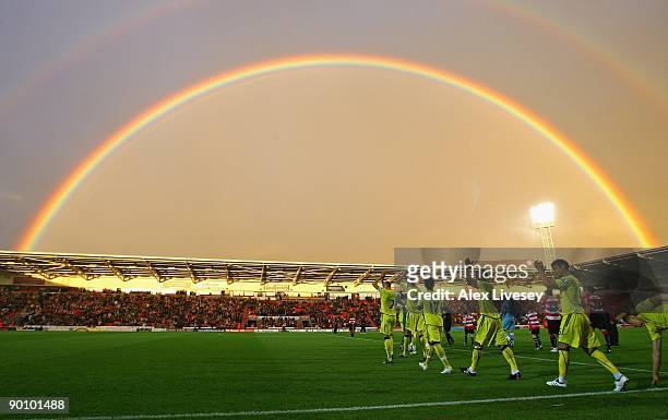 Tottenham Hotspur and Doncaster Rovers players run on to the pitch as a rainbow arches over the Keepmoat Stadium before the Carling Cup second round...