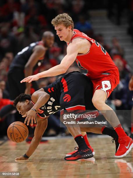 Lauri Markkanen of the Chicago Bulls fouls Kyle Lowry of the Toronto Raptors at the United Center on January 3, 2018 in Chicago, Illinois. The...