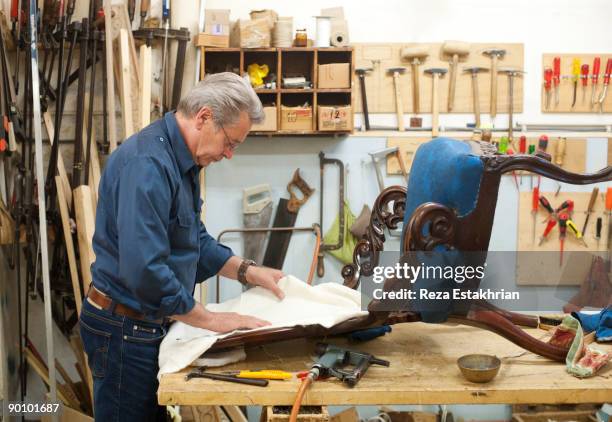 man upholstering antique chair - antique furniture stock pictures, royalty-free photos & images