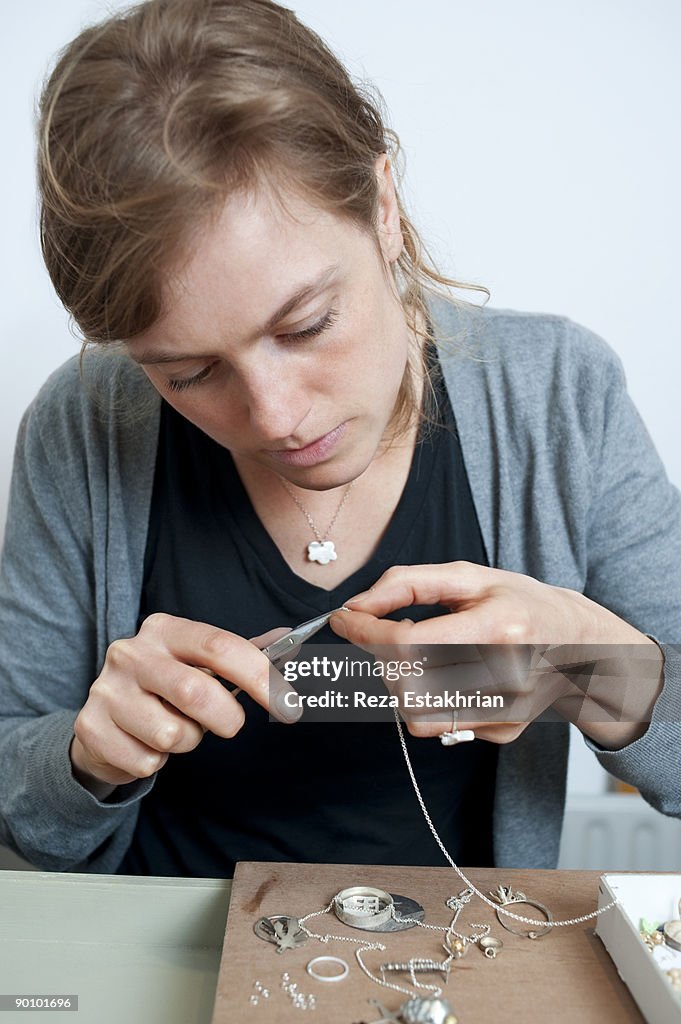 Young woman makes a necklace