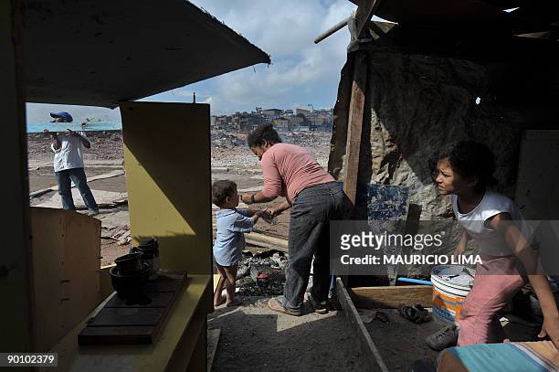 Brazilian homeless mother takes care of her son in an improvised hut set in front of the land they were evicted from, at Capao Redondo shantytown,...