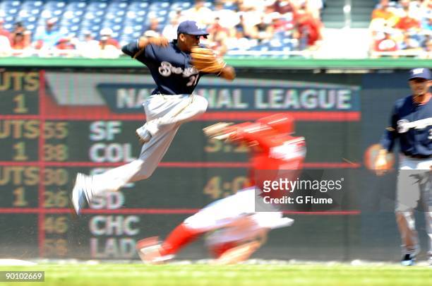 Nyjer Morgan of the Washington Nationals slides under Alcides Escobar of the Milwaukee Brewers to break up a double play at Nationals Park on August...