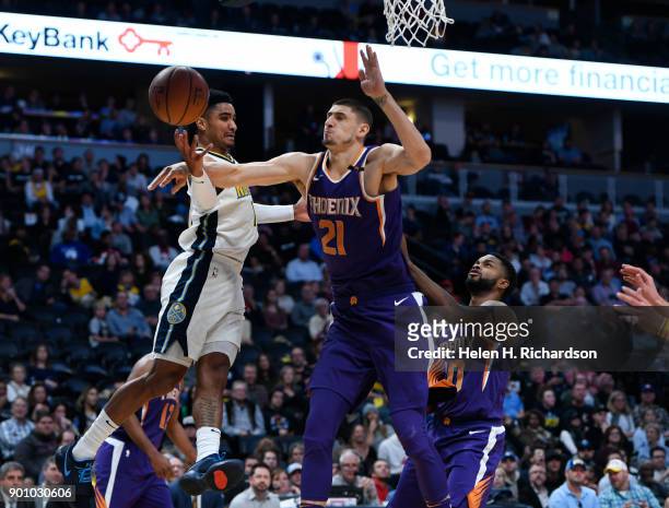 Phoenix Suns center Alex Len, right, blocks a layup attempt by Nuggets guard Gary Harris, left, during the first half of NBA game at Pepsi Center on...