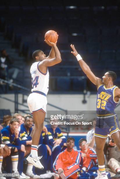 John Williams of the Washington Bullets shoots over Karl Malone of the Utah Jazz during an NBA basketball game circa 1989 at The Capital Centre in...