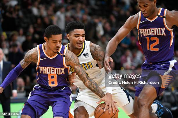 Denver Nuggets guard Gary Harris, #14, fights for the ball against Phoenix Suns' guards Tyler Ulis, #8, left, and T.J. Warren, #12, right, during the...