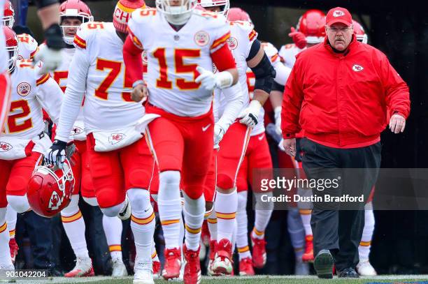 Head coach Andy Reid of the Kansas City Chiefs walks onto the field with players before a game against the Denver Broncos at Sports Authority Field...