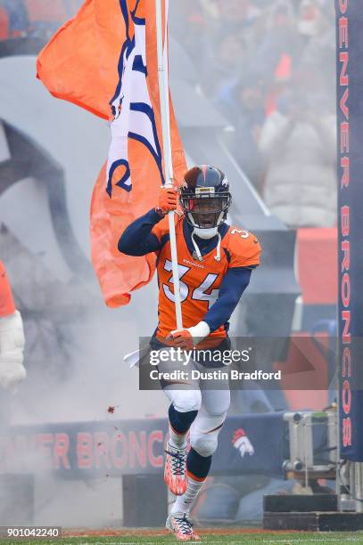 Defensive back Will Parks of the Denver Broncos runs onto the field with a Broncos flag before a game against the Kansas City Chiefs at Sports...