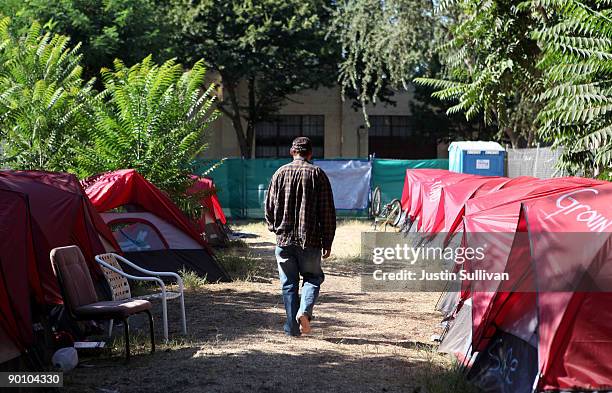 Homeless man named Mike walks through a "Safe Ground" encampment August 26, 2009 in Sacramento, California. Over 30 homeless men and women are hoping...