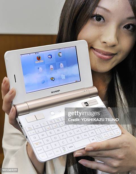 An employee of Japan's electronics giant Sharp poses with a new mobile internet device, the "NetWalker PC-Z1", at the company's showroom in Tokyo on...