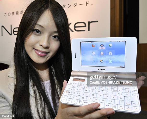 An employee of Japan's electronics giant Sharp poses with a new mobile internet device, the "NetWalker PC-Z1", at the company's showroom in Tokyo on...