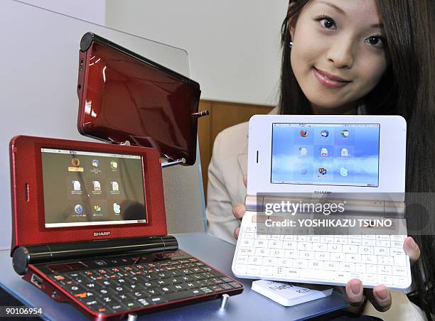 An employee of Japan's electronics giant Sharp poses with a new mobile internet device, the "NetWalker PC-Z1", at the company's showroom in Tokyo on...