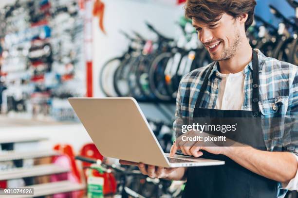 fahrrad-shop-betreiber mit laptop - sportgeschäft stock-fotos und bilder