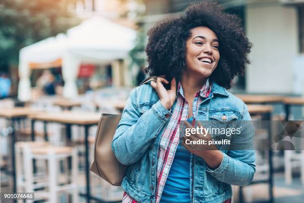 vrolijk meisje buiten wandelen - black purse stockfoto's en -beelden