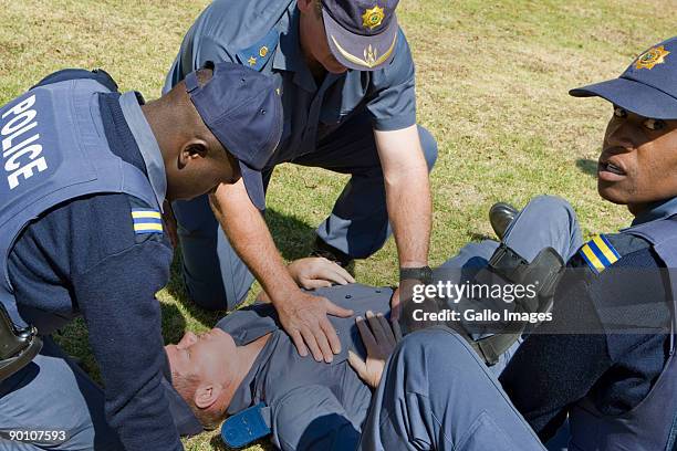 South African Police assist an injured colleague as soldiers participate in an illegal march at the Union Buildings August 26, 2009 in Pretoria,...