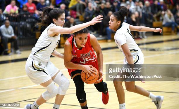 St. John's Cadets Azzi Fudd splits the defense of Paul VI Panthers guard Aurea Gingras and Paul VI Panthers guard Faith Alston in the first half...