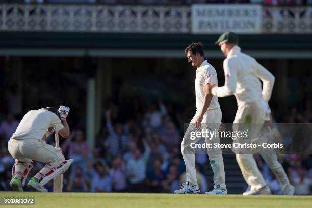 Mitchell Starc of Australia walks past England's Joe Root after he was dismissed for 83 runs caught by Mitch Marsh during day one of the Fifth Test...