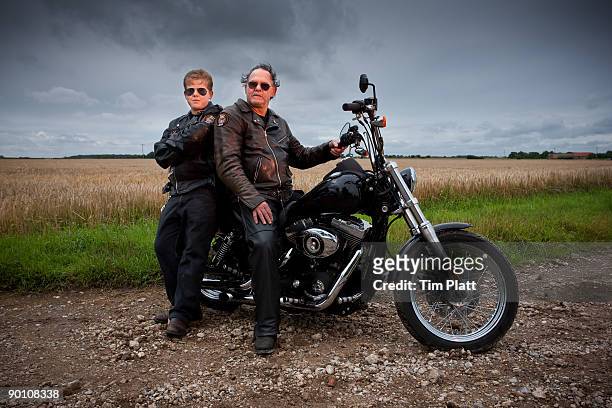 man and son sitting on a motorcycle. - cool man leather stock pictures, royalty-free photos & images