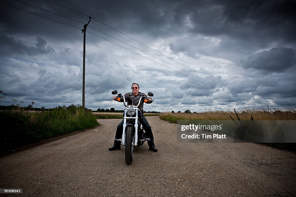 Mature man on a motorcycle.