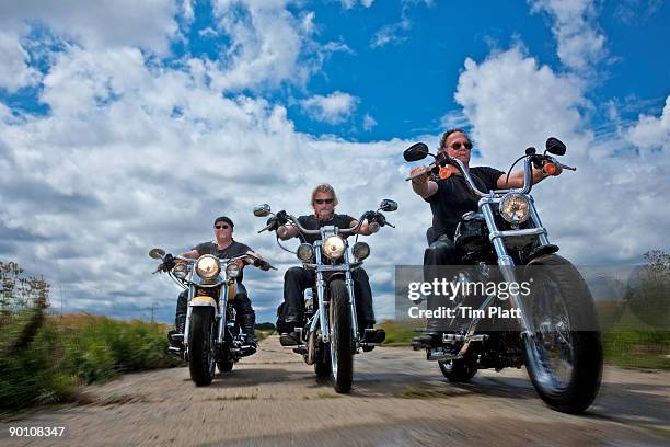 three men riding motorcycles in the countryside. - montare-su-un-veicolo foto e immagini stock