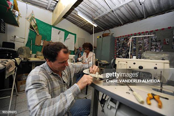 Brazilian 60 year-old seamstress Maria de Lourdes works at her atelier in Dona Marta shantytown, Rio de Janeiro, Brazil on August 25 while a...