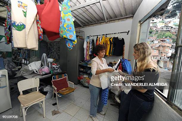 Brazilian 60 year-old seamstress Maria de Lourdes shows her creations to a client at her atelier in Dona Marta shantytown, Rio de Janeiro, Brazil on...