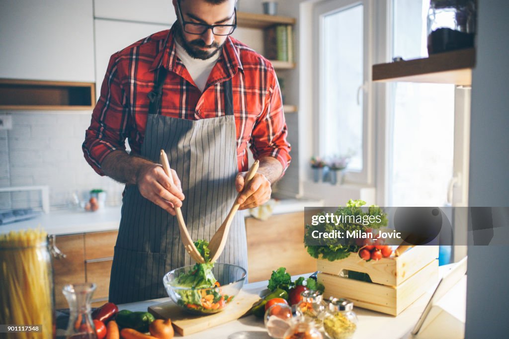 Man preparing vegetable salad at home