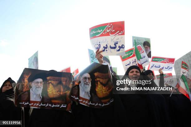 Iranian pro-government supporters hold posters of Iran's supreme leader Ayatollah Ali Khamenei during a rally in support of the regime after...