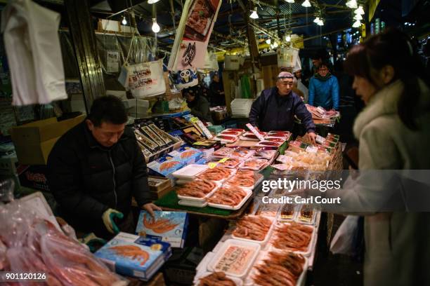 Woman buys prawns at a stall in Ameya Yokocho market on January 4, 2018 in Tokyo, Japan. Ameya Yokocho, claimed to be Tokyo's last remaining open air...